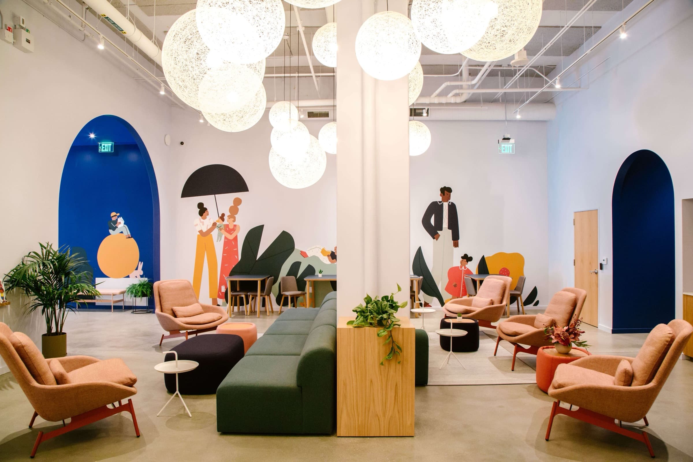Brella's main lounge — a light-filled room with cloud-like pendant lamps, illustrated wall murals, arched blue alcoves, and soft modern seating